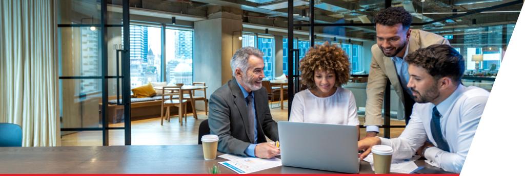 Four colleagues working around a computer in an office