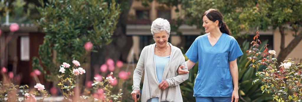 Nurse Walking With an Older Patient