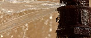 Damaged pipe spewing water | CNA Insurance