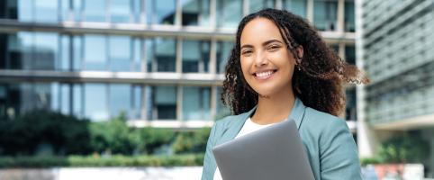 Financial analyst smiling in front of building | CNA Insurance